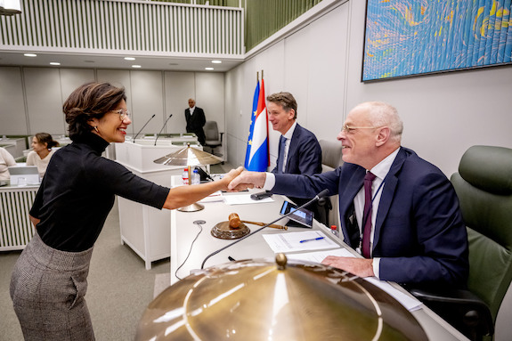 De staatssecretaris schudt de hand van Kamervoorzitter Bruijn