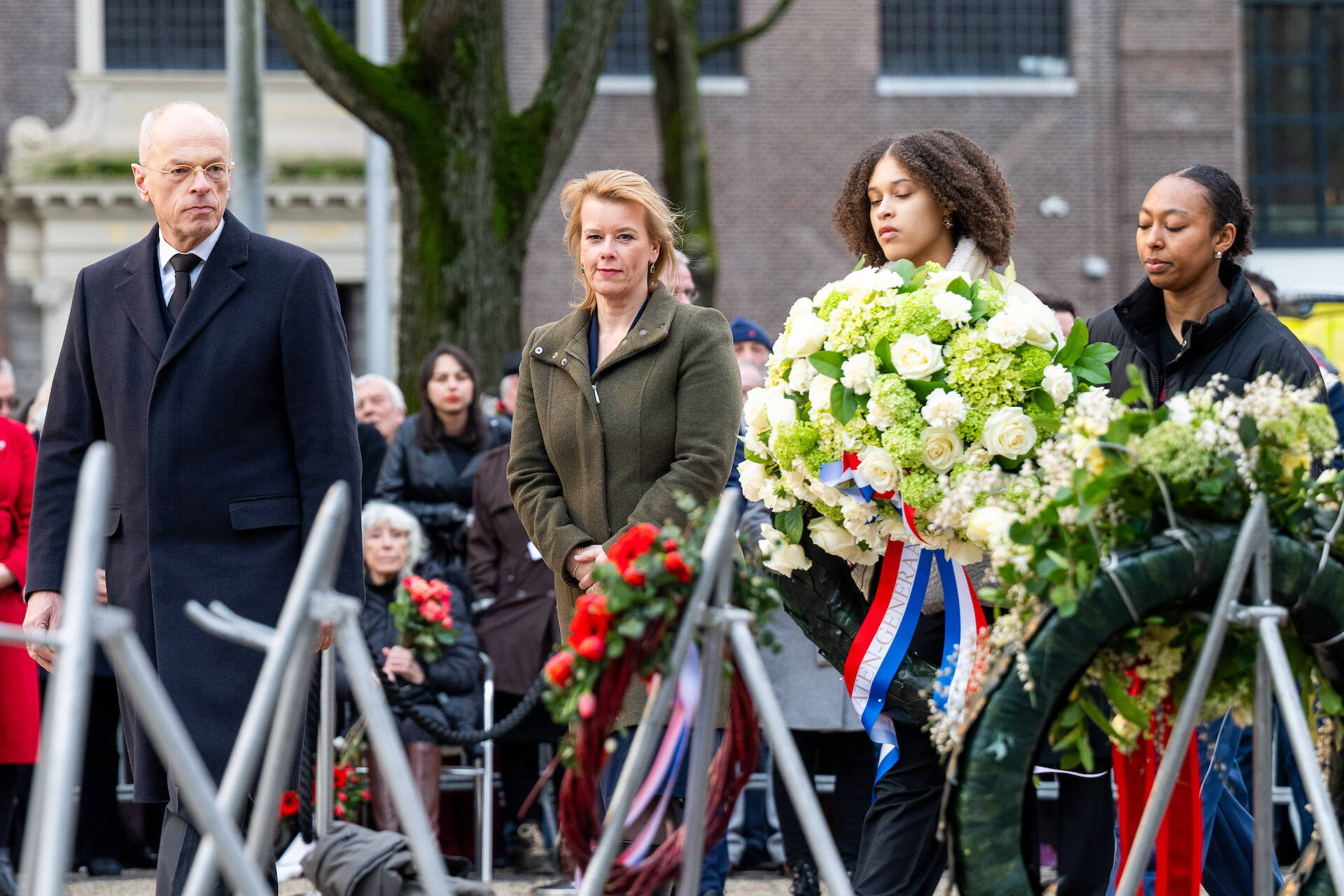 Jan Anthonie Bruijn en Roelien Kamminga lopen langs de kransen