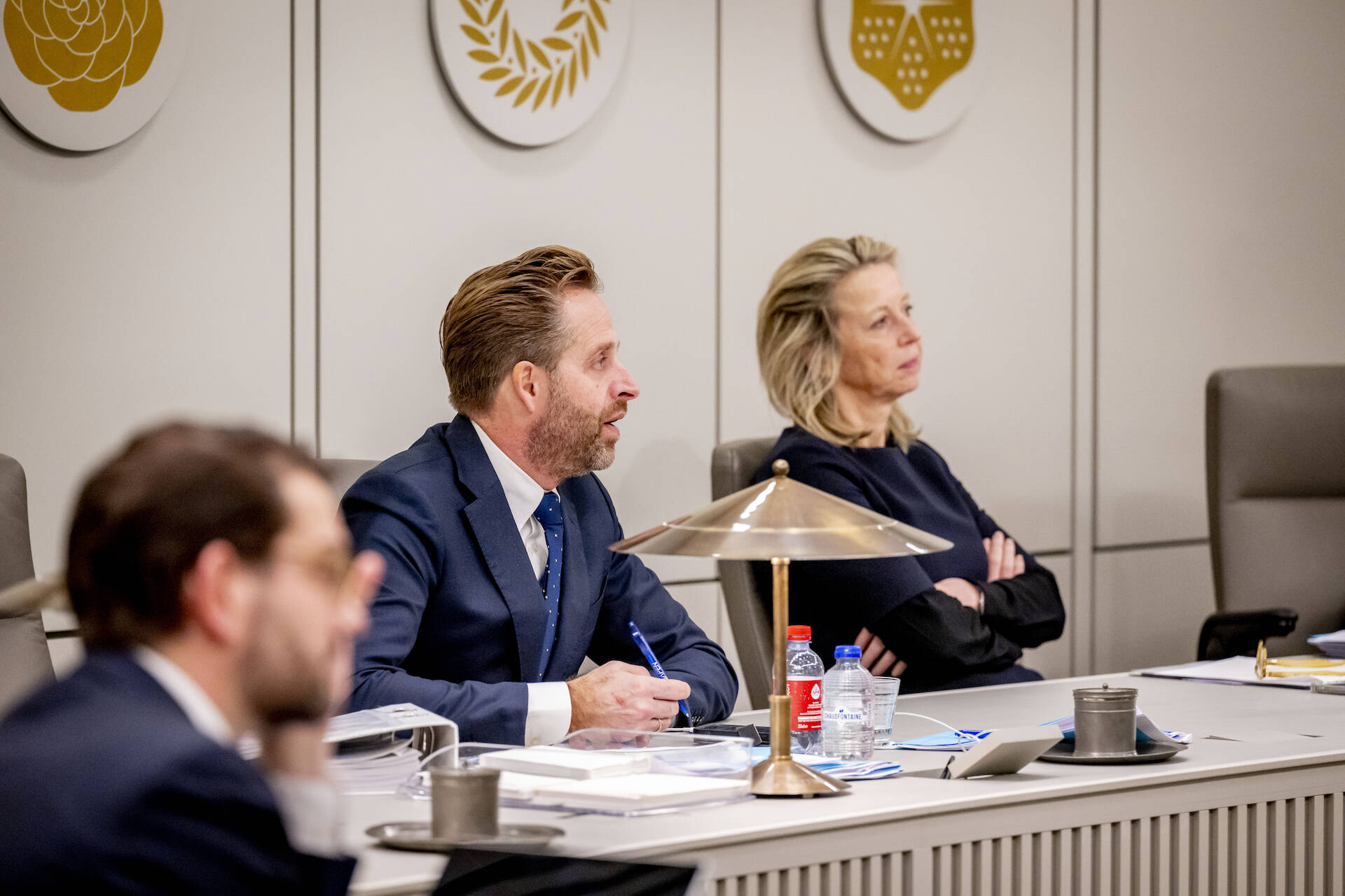 Minister De Jonge en minister Ollongren luisteren naar de Kamer