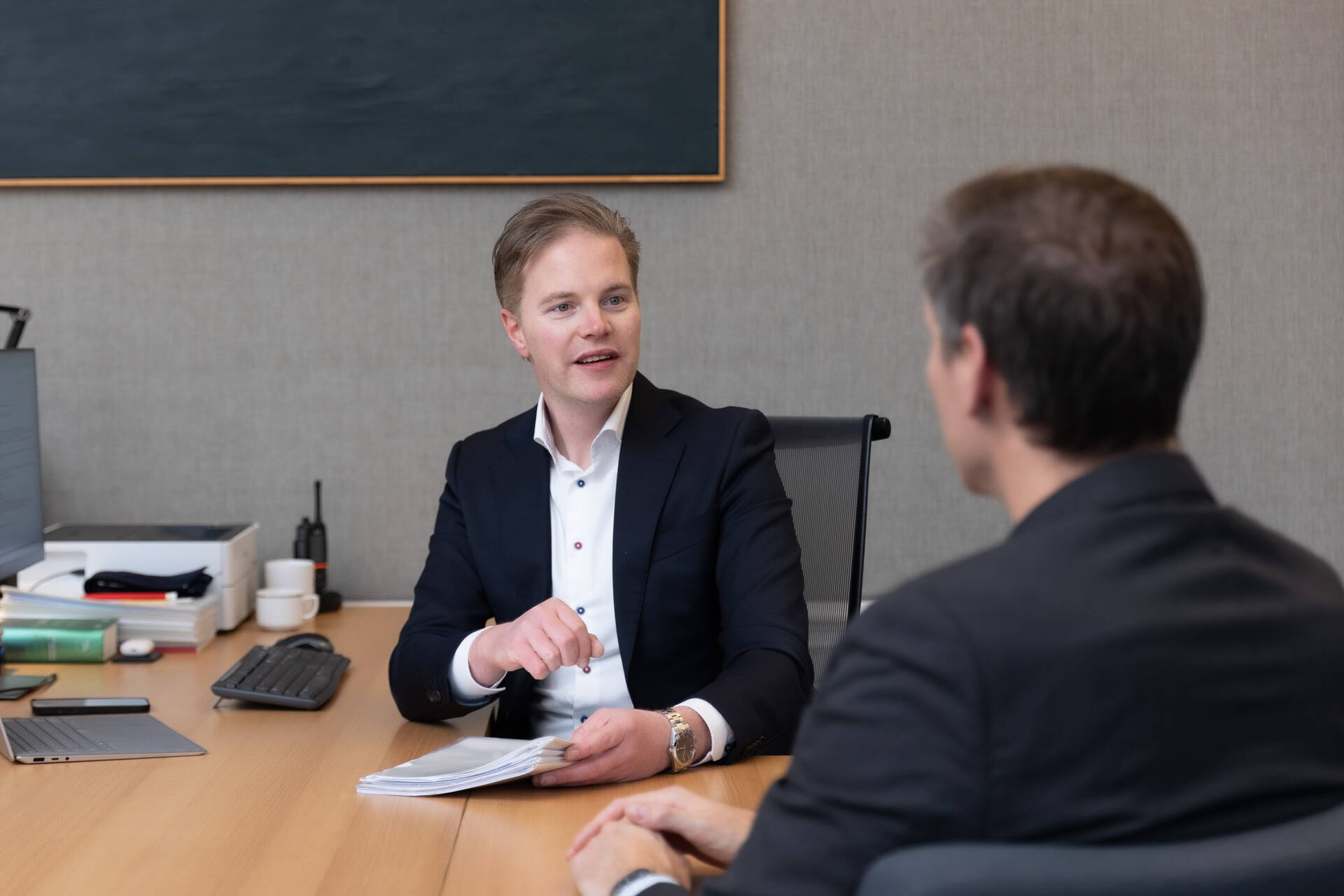 Collega's praten met elkaar aan een bureau.