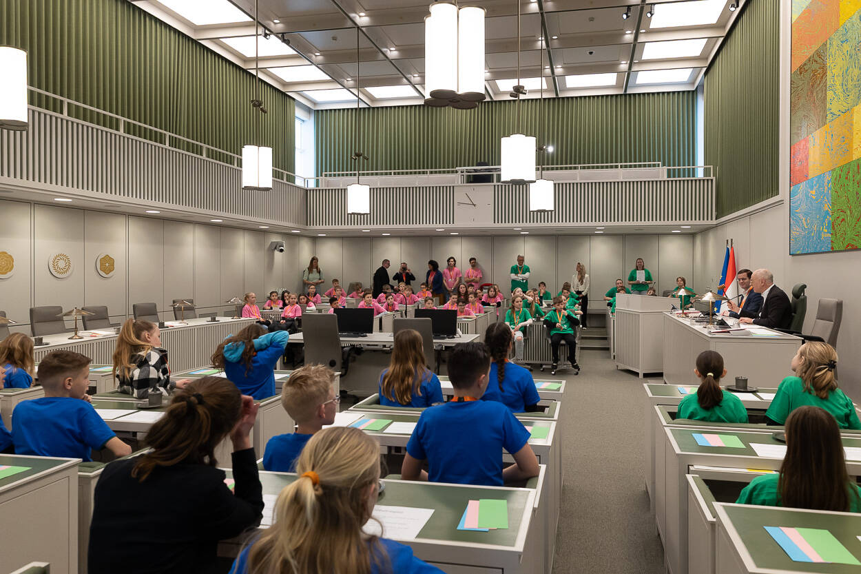 Kinderen met gekleurde shirts in de bankjes.