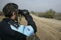Frontex agent die door een verrekijker kijkt